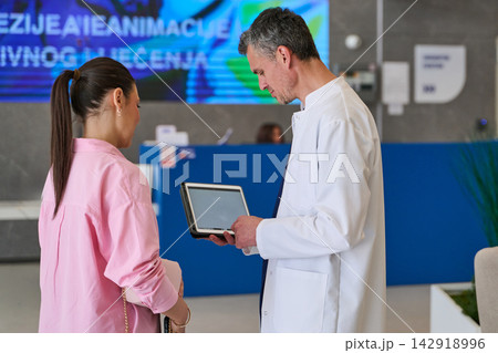 Medical professional consulting with a patient in a modern healthcare facility during daytime Medical professional consulting with a patient in a modern healthcare facility during daytime 142918996