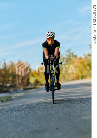 Focused Cyclist Training on Road Bike During Outdoor Endurance Ride in Clear Weather Focused Cyclist Training on Road Bike During Outdoor Endurance Ride in Clear Weather 142919278