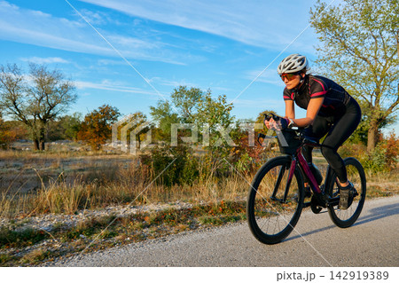 Female Cyclist Training On Road Bike In Countryside During Sunny Outdoor Fitness Ride Female Cyclist Training On Road Bike In Countryside During Sunny Outdoor Fitness Ride 142919389