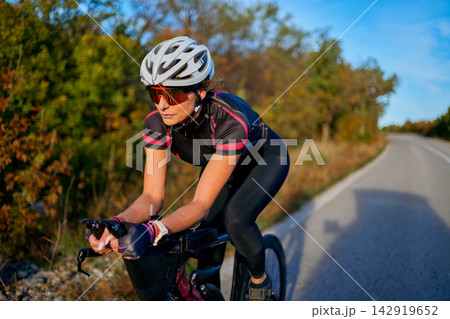 Female Road Cyclist Training on Scenic Countryside Route During Golden Hour Outdoor Cycling Workout Female Road Cyclist Training on Scenic Countryside Route During Golden Hour Outdoor Cycling Workout 142919652