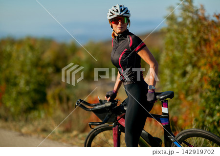 Female Cyclist With Road Bike Outdoors In Autumn Training Gear Looking Confident And Focused Female Cyclist With Road Bike Outdoors In Autumn Training Gear Looking Confident And Focused 142919702