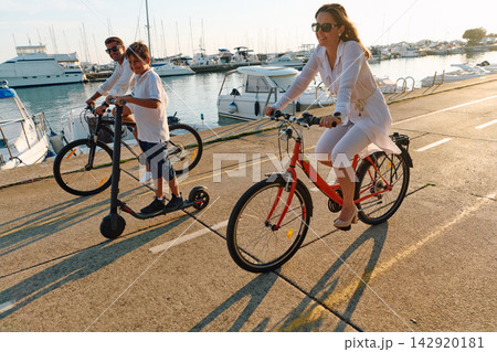 Family Cycling and Scooting by Marina At Sunset Parents and Child Enjoy Waterfront Ride Together 142920181