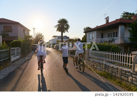 Family Cycling Together At Sunset On A Quiet Residential Street Near Umag Family Cycling Together At Sunset On A Quiet Residential Street Near Umag 142920195