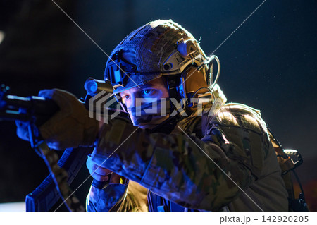 Special Forces Soldier Aiming Rifle During Night Tactical Operation With Helmet And Comms Gear Special Forces Soldier Aiming Rifle During Night Tactical Operation With Helmet And Comms Gear 142920205