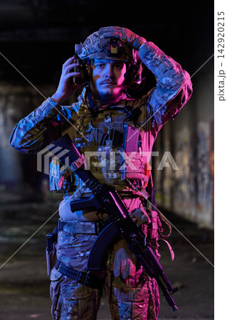 Tactical Soldier In Night Urban Operation Wearing Helmet And Combat Gear With Rifle 142920215