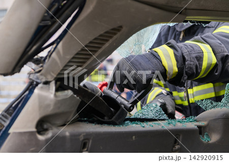 Firefighter Using Hydraulic Rescue Tool To Extract Victim From Crashed Car With Broken Glass Firefighter Using Hydraulic Rescue Tool To Extract Victim From Crashed Car With Broken Glass 142920915