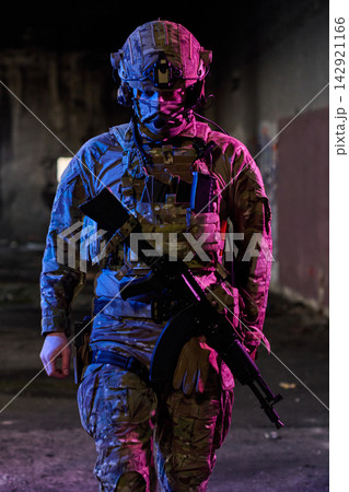 Armed Soldier in Tactical Gear Patrolling Abandoned Urban Building Under Colored Lighting 142921166