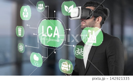 Professional male in virtual reality headset engaging with life cycle assessment concepts in modern office environment showing sustainability and technology integration Gluon Professional male in virtual reality headset engaging with life cycle assessment concepts in modern office environment showing sustainability and technology integration Gluon 142921335