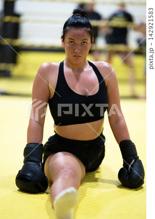 Female Boxer Training in Ring With Gloves Showing Determination, Strength and Fitness 142921583