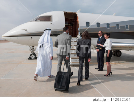 Middle Eastern business team boarding private jet at airport for corporate travel Middle Eastern business team boarding private jet at airport for corporate travel 142922164