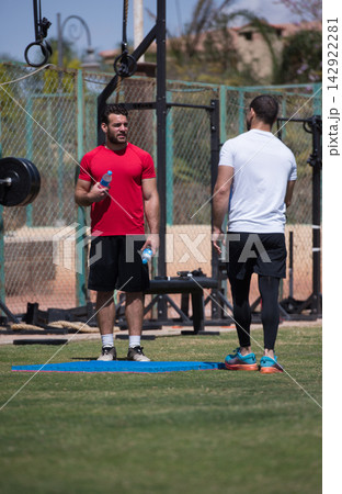 Middle Eastern Arab men chatting during outdoor CrossFit workout and fitness training session Middle Eastern Arab men chatting during outdoor CrossFit workout and fitness training session 142922281