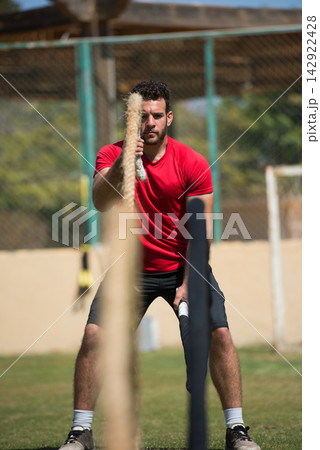 Man training with battle ropes in outdoor fitness area during partner crossfit workout session 142922428