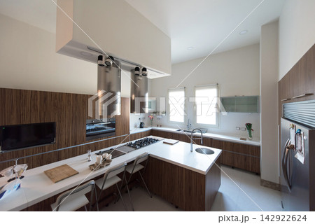 Modern Middle Eastern Arab family kitchen with spacious island, wood cabinetry and bright natural light 142922624