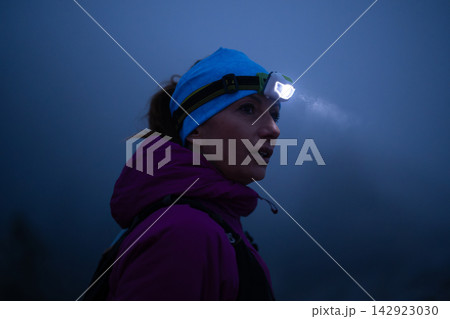 Woman Hiker Wearing Headlamp At Night On Foggy Outdoor Trail During Cold Weather Adventure 142923030