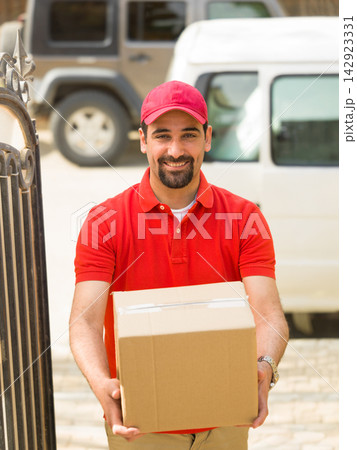 Delivery man bringing a package to a Middle Eastern family at a modern luxury villa 142923331