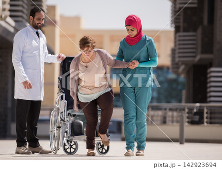 Doctors and nurse assist older patient from wheelchair at a modern Middle Eastern eye hospital in Egypt Doctors and nurse assist older patient from wheelchair at a modern Middle Eastern eye hospital in Egypt 142923694