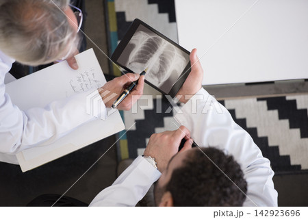 Doctors reviewing chest x-ray on tablet during consultation at a modern eye hospital clinic in Egypt Doctors reviewing chest x-ray on tablet during consultation at a modern eye hospital clinic in Egypt 142923696