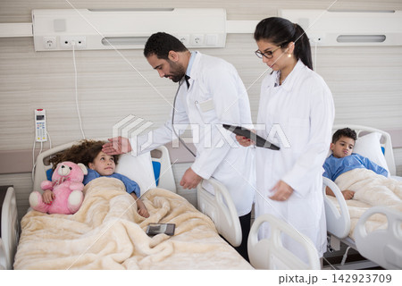 Doctors examining and comforting pediatric patients in a modern Middle Eastern eye hospital clinic in Egypt 142923709
