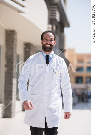 Middle Eastern eye doctor in white coat standing outside a modern eye clinic in Egypt 142923770