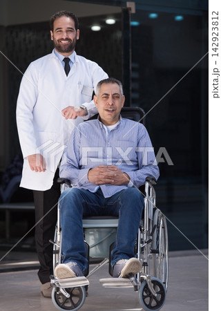 Middle Eastern eye hospital doctor with patient in wheelchair at modern clinic in Egypt Middle Eastern eye hospital doctor with patient in wheelchair at modern clinic in Egypt 142923812