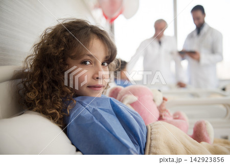 Young girl patient in a Middle Eastern eye hospital bed with doctors consulting in an Egyptian clinic 142923856