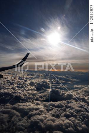 飛行機の翼と雲海 上空から眺める美しい雲と光 142923977