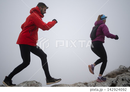 Trail Running Couple Hiking on Foggy Mountain Ridge in Cold Weather Outdoor Adventure 142924092