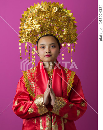 Young Indonesian Asian Girl Wearing Ornate Gold Headdress and Traditional Red Chinese Costume Portrait Young Indonesian Asian Girl Wearing Ornate Gold Headdress and Traditional Red Chinese Costume Portrait 142924324