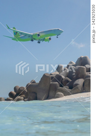下地島空港17ENDにランディングアプローチする旅客機と透明度の高い美ら海 142925030