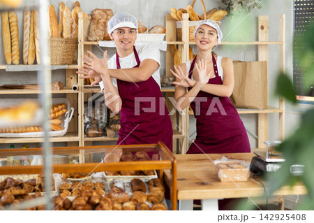 Young sellers standing in bake house, ready to greet customers Young sellers standing in bake house, ready to greet customers 142925408