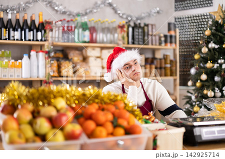 Seller sits thoughtfully near the counter Seller sits thoughtfully near the counter 142925714