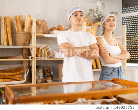 Young woman and guy sellers at counter in bakery 142925753
