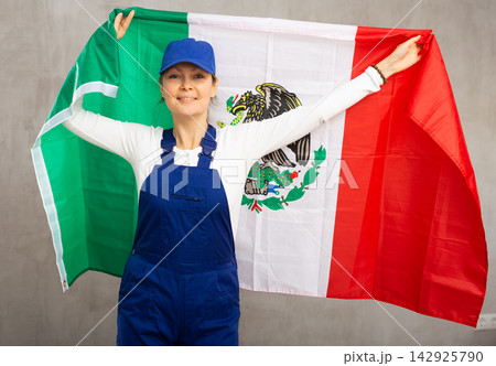 Smiling mature woman in uniform holding Mexico flag 142925790