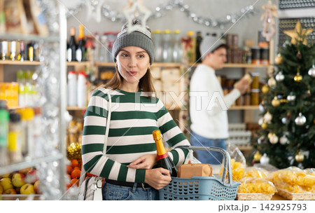 Woman with grocery basket in supermarket 142925793