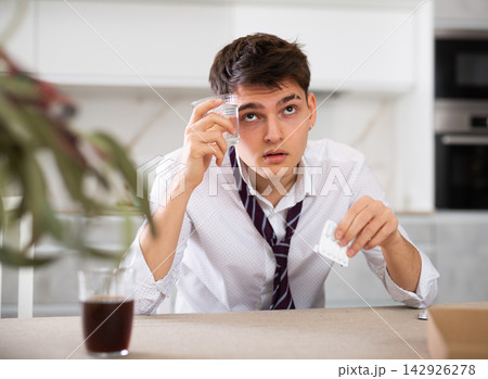 young man suffering from hangover young man suffering from hangover 142926278