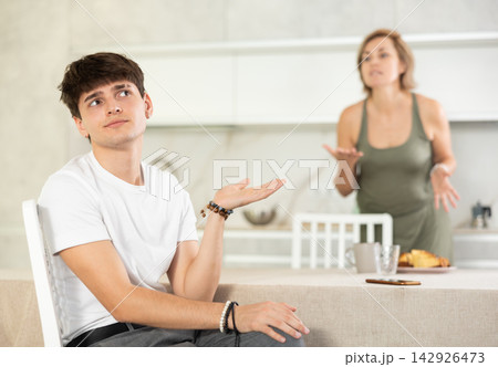 Adult woman quarreling with young guy in kitchen 142926473