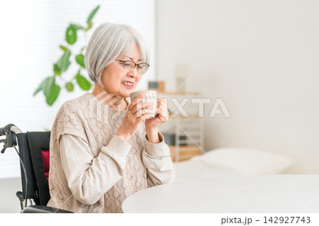 車椅子で暮らすシニア女性が日本茶を飲みながら家でくつろぐひととき 車椅子で暮らすシニア女性が日本茶を飲みながら家でくつろぐひととき 142927743