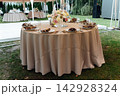 Elegant wedding table setting with floral centerpiece and candles under a marquee tent. 142928324