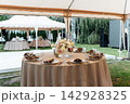 Elegant wedding table setting with floral centerpiece and candles under a marquee tent. 142928325
