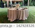 Elegant wedding table setting with floral centerpiece and candles under a marquee tent. 142928326