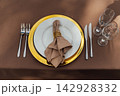 Elegant wedding table setting detail with plates, napkins and golden rings. 142928332