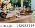 Elegant wedding table setting detail with plates, napkins and golden rings. 142928336