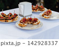 Gourmet catering bruschetta appetizers with prosciutto and roast beef on event buffet table. 142928337