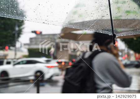 雨の日に傘を差して歩道を歩く人々 雨の日に傘を差して歩道を歩く人々 142929075