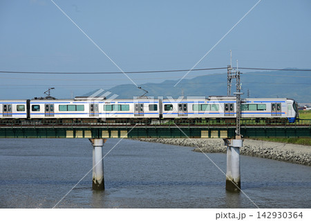 青空と川の鉄橋を渡る西日本鉄道の特急形ステンレス電車 142930364