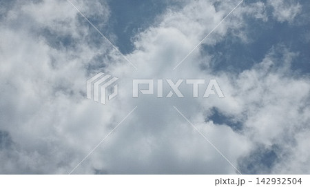 Bright sunny day with soft white clouds scattered across the blue sky Bright sunny day with soft white clouds scattered across the blue sky 142932504