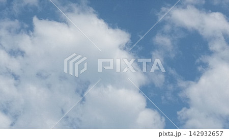 Scenic daytime sky featuring scattered white clouds and blue expanse 142932657