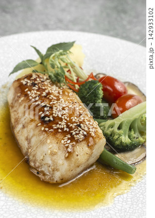 asian style fusion cod fillet with vegetables and sweet sesame ginger sauce on restaurant table asian style fusion cod fillet with vegetables and sweet sesame ginger sauce on restaurant table 142933102
