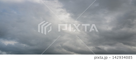 Panoramic view of dramatic gray storm clouds with patches of blue sky Panoramic view of dramatic gray storm clouds with patches of blue sky 142934085