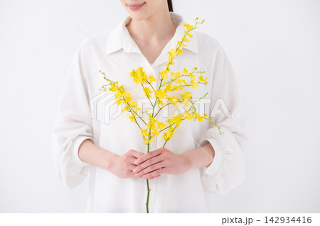 花束を持つ女性　オンシジウム　手元 142934416